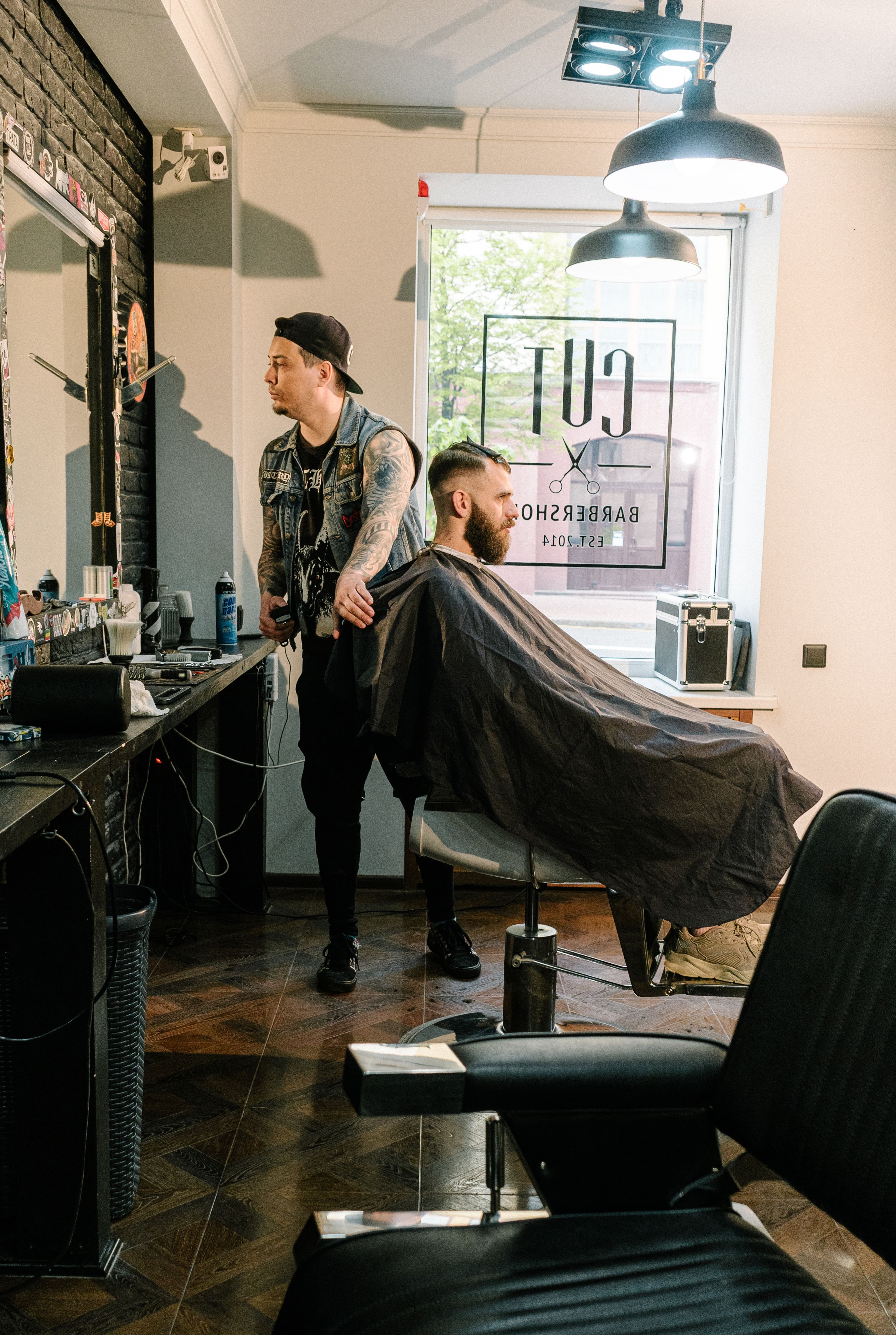 Barbero tradicional aplicando toalla caliente y espuma para afeitado clasico de barba